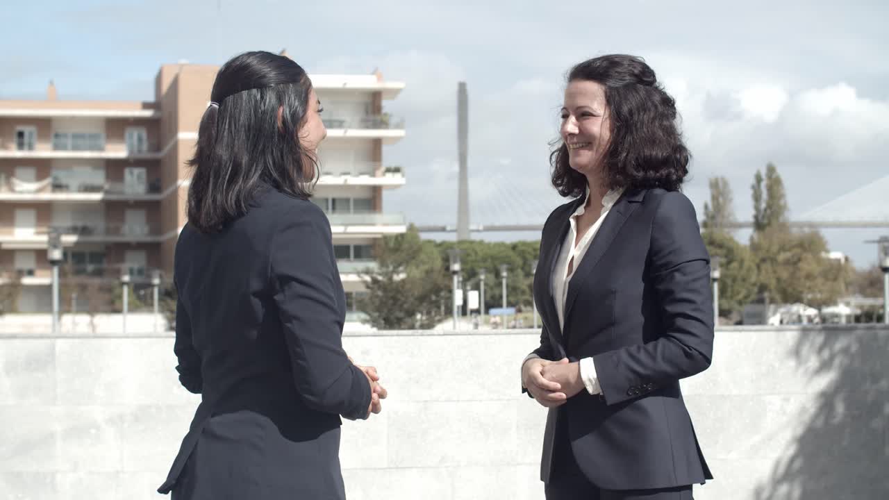 Belle donne d'affari soddisfatte che si stringono la mano.