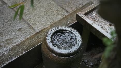 Water-Drops-Falling-into-Stone-Basin-in-Slow-Motion,-Fushimi-Inari