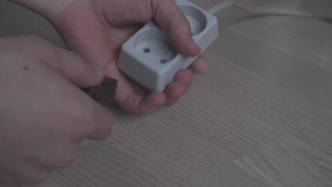 manos enchufando-desenchufando la vieja tira eléctrica europea