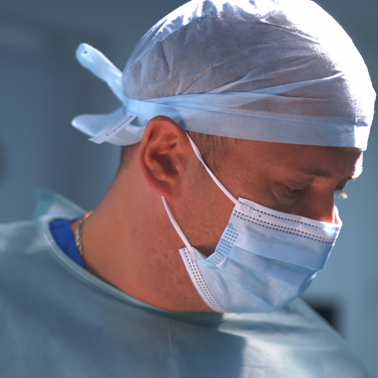 Professional plastic surgery specialist in mask. Surgeon using medical scissors during plastic surgery in the operating room