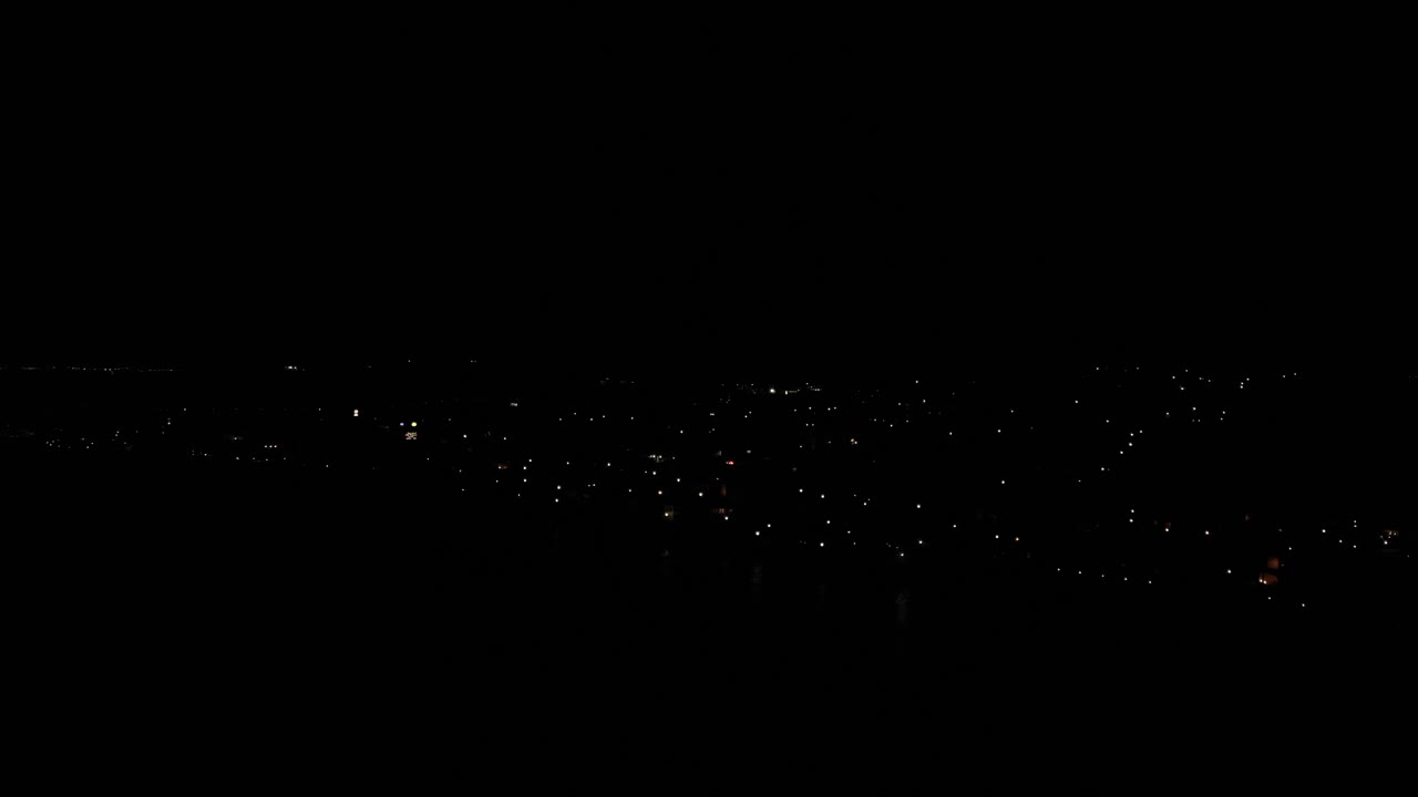 건물의 불빛만 보이는 에스테포나 마을의 어두운 밤하늘 전망