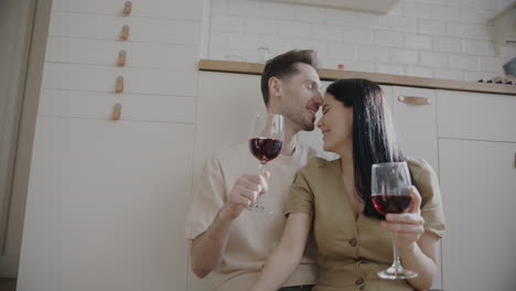 couple celebrating with wine in kitchen