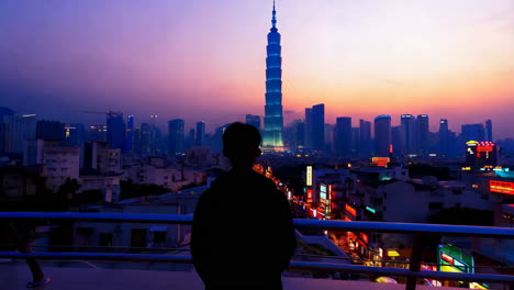 silhouette of a person overlooking the taipei cityscape at twilight