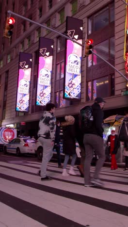 new york city street scene at night with taco bell billboards