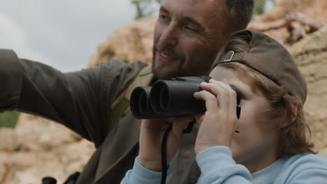 father and son exploring nature with binoculars