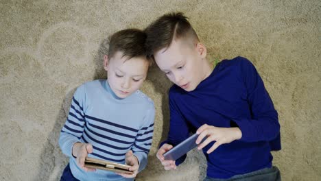 little boys playing game on mobile together. child playing video game at home
