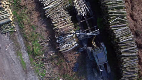 Vista-Aérea-De-Arriba-Hacia-Abajo-De-Un-Tractor-Que-Carga-Trozos-De-Madera-En-Un-Remolque-En-Un-Depósito-De-Madera