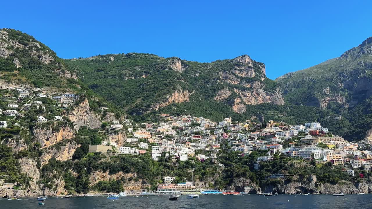 Positano village commune on the Amalfi Coast in Campania, Italy on rugged hills leading down to the coast - view from a boat