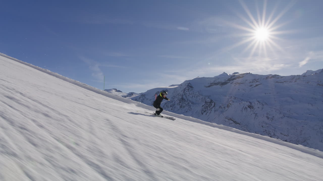 Skiing in Zermatt under the Matterhorn during a blue bird day and perfect slopes. High performance carving on skis.
