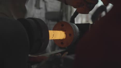 blacksmith forging metal, hot spinning steel on a lathe during manufacturing