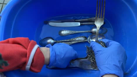 zilveren gereedschap in een schaal wassen