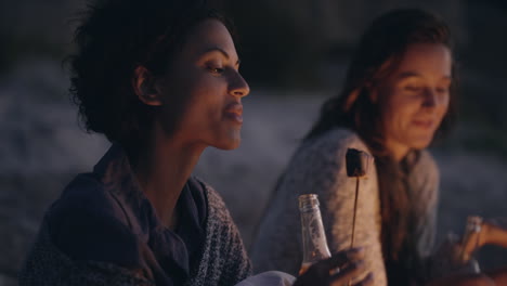 beach party at sunset with bonfire and roasting marshmellows with friends