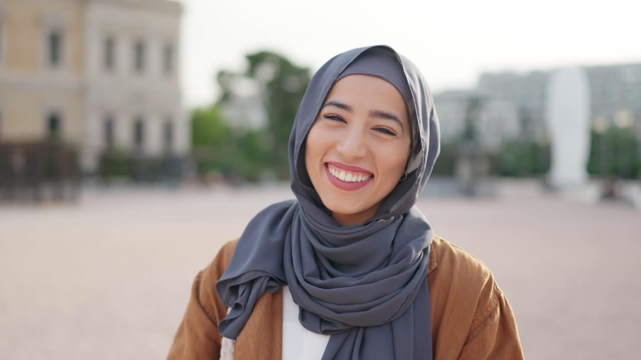 Portrait of a happy young Muslim woman in a grey hijab smiling outdoors
