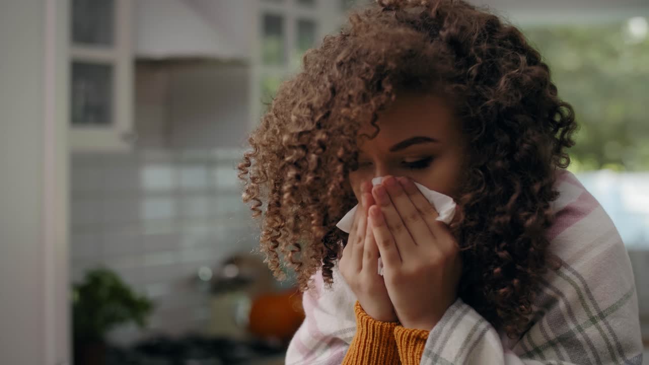 mujer joven con gripe y soplando la nariz en pañuelo/rzeszow/polonia