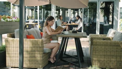 woman reading menu at outdoor cafe
