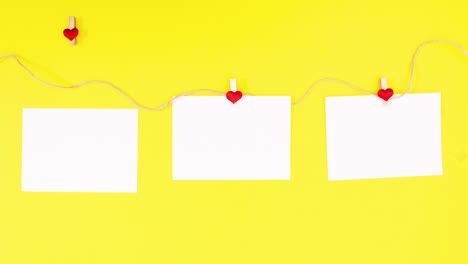 papers hooping on rope for valentines day text on yellow theme. stop motion