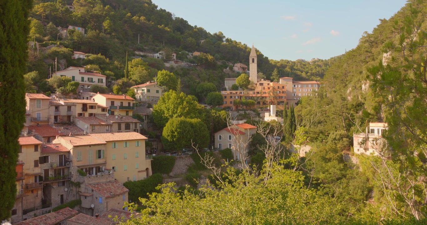 Vista pittoresca di Peille, un borgo medievale storico con case in pietra addossate e tetti in terracotta, arroccato su un fianco di montagna, Alpi Marittime, Sud della Francia.