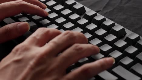 hands of a man typing text on a mechanical keyboard without printed letters