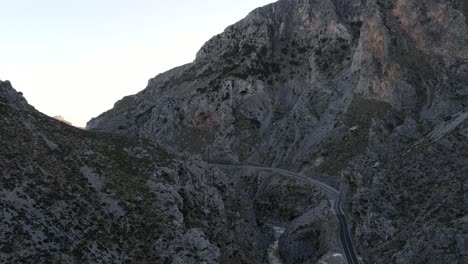 drone flying above serpentine road in rocky mountain koutaliotiko gorge