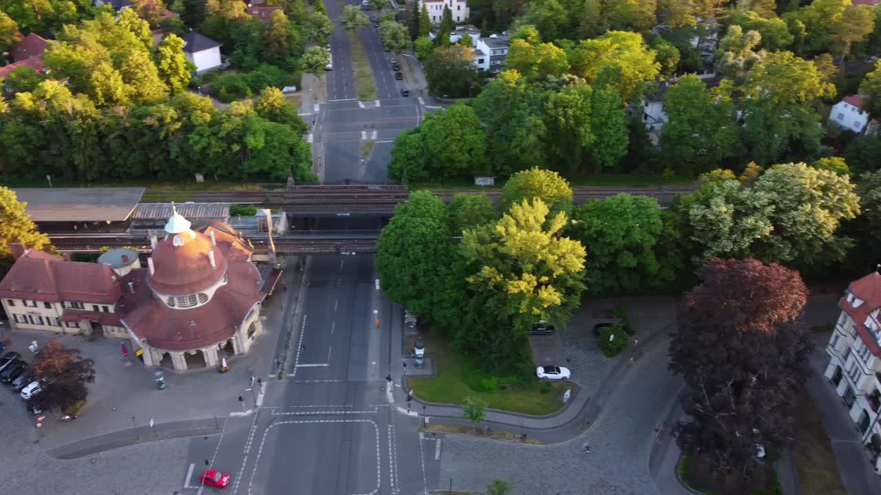 estación amarilla de s-bahn sobre el puente hermosa vista aérea vuelo de persecución imágenes de drones de mexikoplatz berlín zehlendorf hora dorada verano 2022 vista cinematográfica desde arriba guía turística por philipp marnitz
