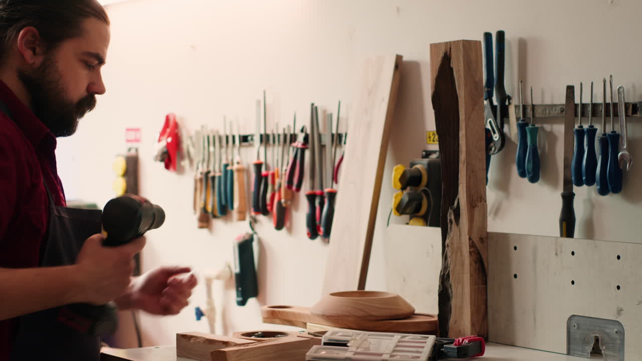 Carpenter changing power drill head in furniture assembly shop