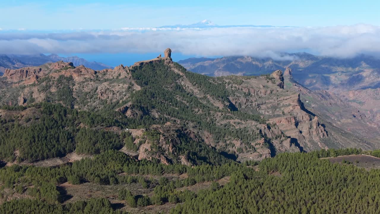Splendida prospettiva aerea dell'iconica formazione rocciosa Roque Nublo a Gran Canaria, con il vulcano Teide visibile sopra le nuvole.