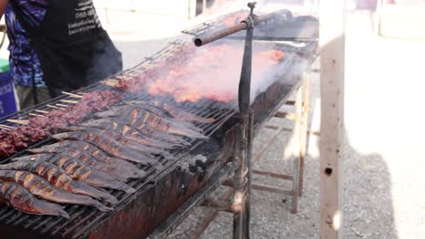 skewers of meat cooking on a large grill