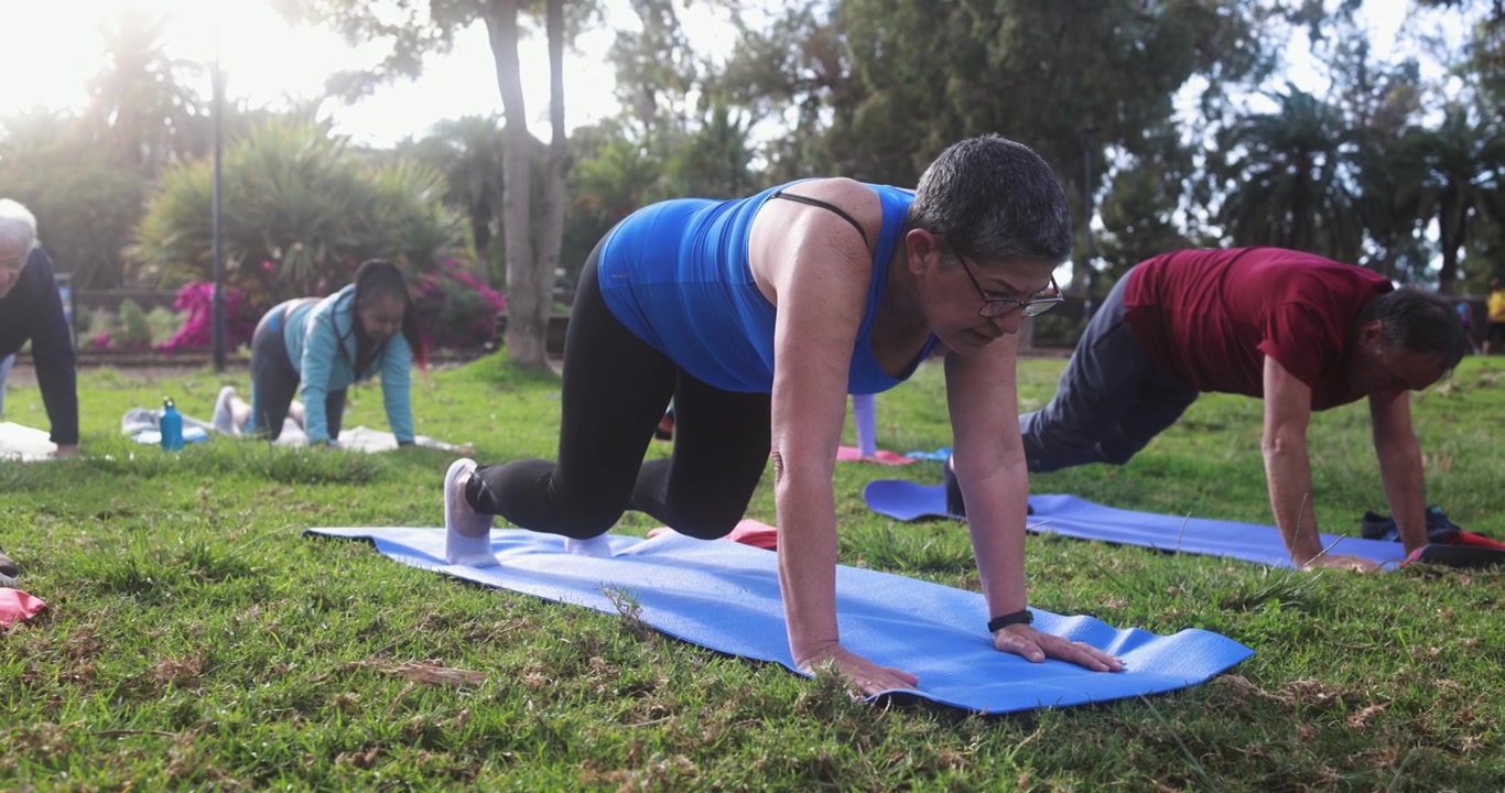 Diverse Senior Adults Exercising Outdoors on Yoga Mats