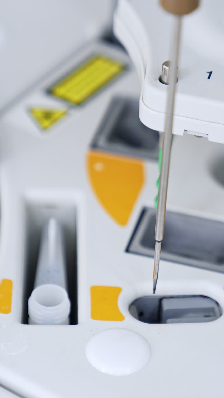 Slots at the medical testing equipment with metal needle moving from one slot to another. New equipment at modern science laboratory. Vertical video