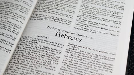 close up shot of bible page turning to the book of hebrews