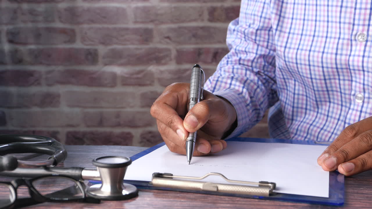 Médico escrevendo notas médicas