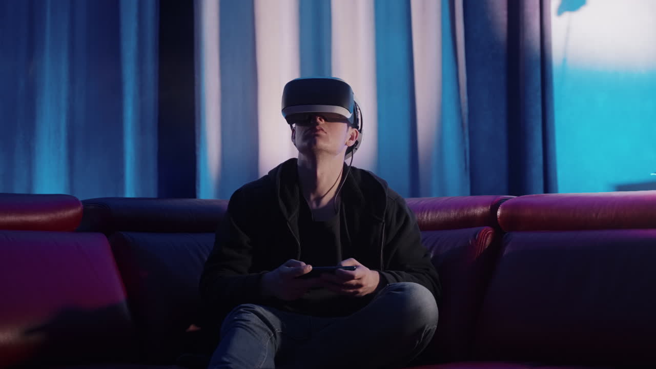 Man Playing VR Games on Couch at Night