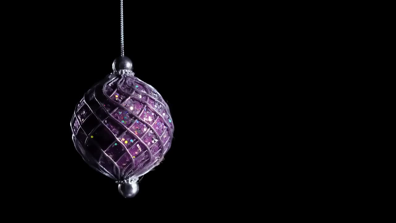 4k. New year ball toy rotates shining and luminating the light. Christmas and New Year decoration isolated on black background. glass christmas ornament.