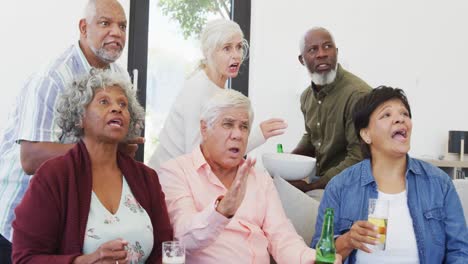 personas mayores felices y diversas viendo televisión con cerveza en el hogar de ancianos