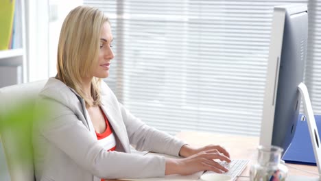 businesswoman using mobile phone while working on computer