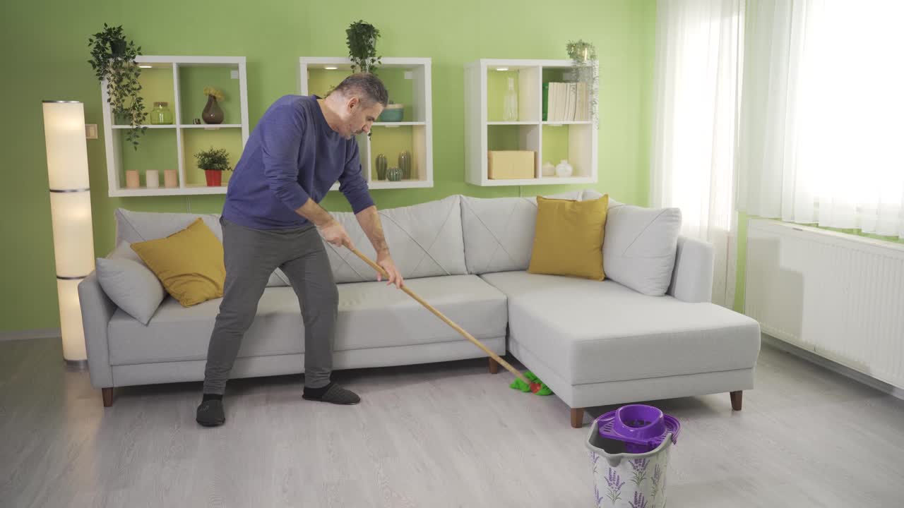 el anciano maduro hace su propia limpieza en casa y se cansa mucho.