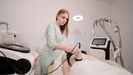 tratamiento de contorno corporal de cavitación. mujer recibiendo terapia anti-celulitis y anti-grasa en un salón de belleza