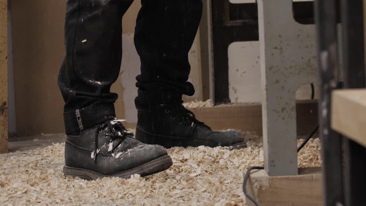 Wood chips falling on a woodworker's feet