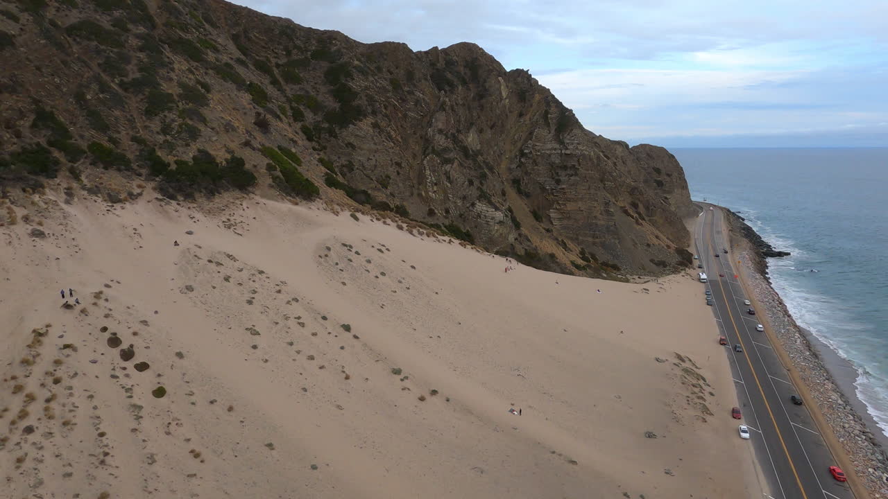 volando sobre las montañas de santa mónica en malibu, california, olas del mar al lado de la carretera