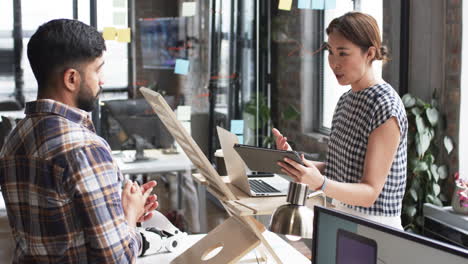 Young-Asian-man-and-Asian-woman-engage-in-a-business-discussion-at-a-modern-office