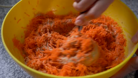 mezclar la masa de pastel de zanahoria en un tazón con harina integral y zanahoria rallada