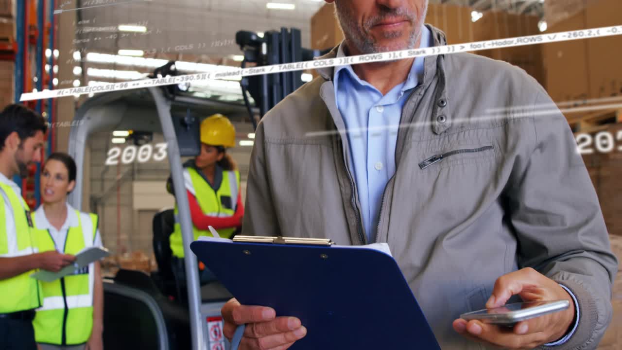 Supervisor listening smartphone call and noting digital trend while tracking warehouse performance