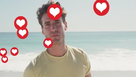animation of social media heart icons over portrait of smiling man on beach