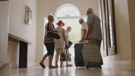 Gruppe-älterer-Freunde-Mit-Gepäck,-Die-Die-Haustür-öffnen-Und-In-Den-Urlaub-Fahren