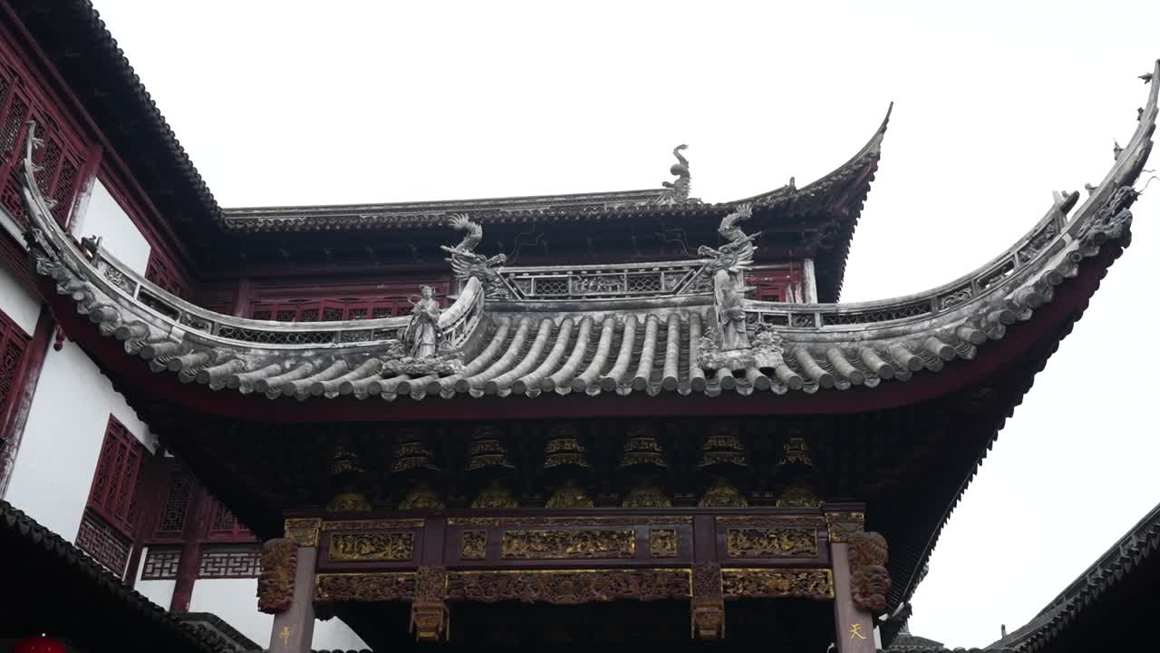 Grey pagoda roof adorned with dragon motifs and carved figures in Yuyuan Garden, Shanghai, China