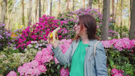 middle-aged woman enjoys banana walk in spring rhododendron garden slow motion