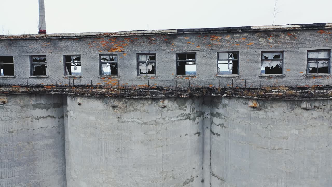 Broken windows and walls of an old chemical plant. Moss-covered concrete vault. Ruins of industrial buildings. Aerial view