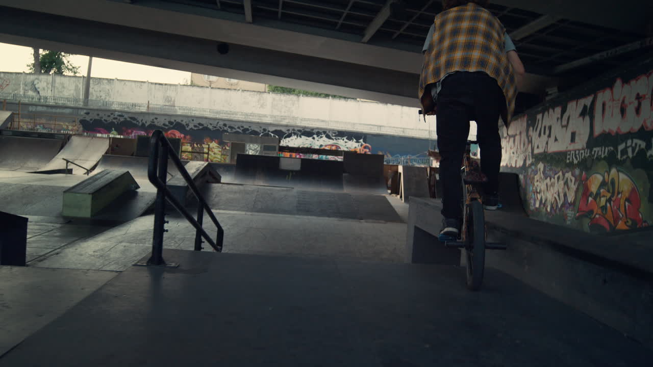 Ekstrem cykelrytter på BMX-cykel racer på rampe i skatepark til aktiv sport og fritid