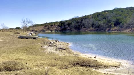 una hermosa escena natural soleada de un lago oasis y vegetación en la región montañosa de texas