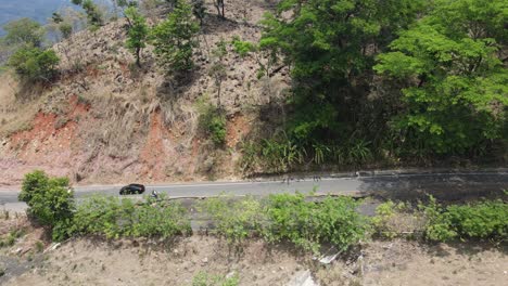 aerial view of cars driving on a road in a desert area with a panoramic view at the end